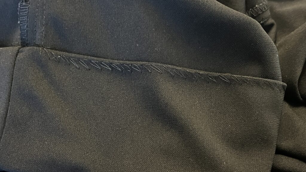 This hem was done on a blind hemmer machine and was falling on more than half of the skirt. The stitching line is sloppy and poorly executed. | No Cut Alterations | No Cut Hems | Services Provided | Stacey Sansom Designs